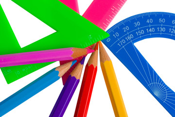 Multicolored rulers, triangle, protractor and color pencils (isolated on white)