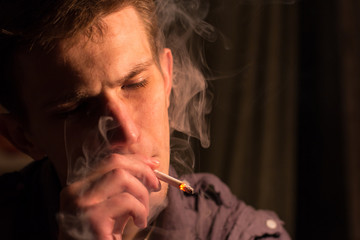 young man alone smokes cigarettes