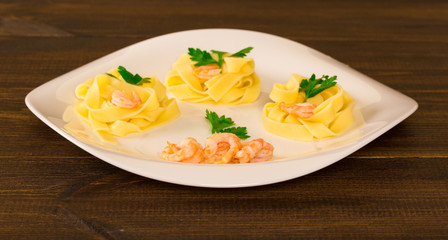 pasta decorated shrimp with parsley on a wooden background