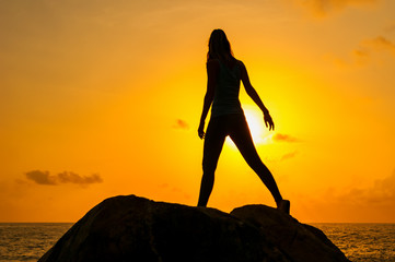 Girl walk along the cliffs by the sea at dawn