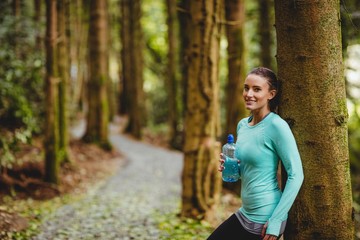 Fit brunette taking a break and holding bottle