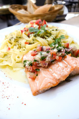 close-up of plate of pasta and smoked salmon with tomato