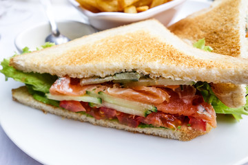 Sandwich with chicken, cheese and golden French fries potatoes