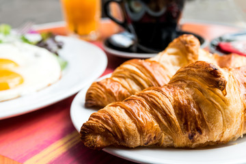 Breakfast with coffee and croissants on table