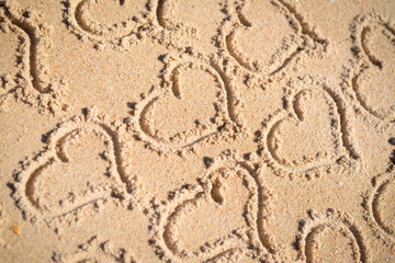Hearts drawn on texture of sand background