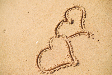 Two hearts drawn on the sand of a beach
