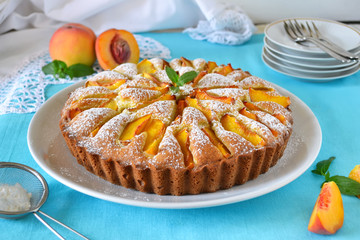 Delicate cake with peaches, dusted with icing sugar