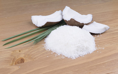 broken coconut lies on a wooden surface. Coconut is scattered.
