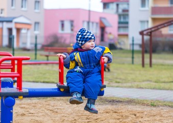 Obraz premium Little boy playing outdoor on city playground