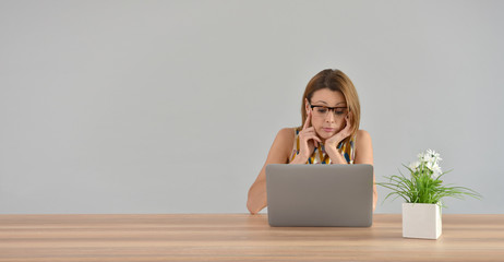 Woman in front of laptop with boring look, isolated