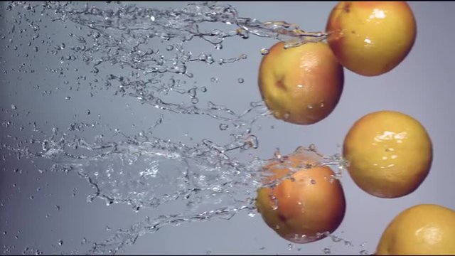 grapefruits are flying with a jet of water on a white background, slow motion