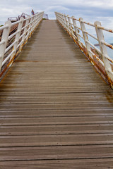 Fototapeta premium Iron bridge with wooden floors and rust by the sea, in Aviles, Spain