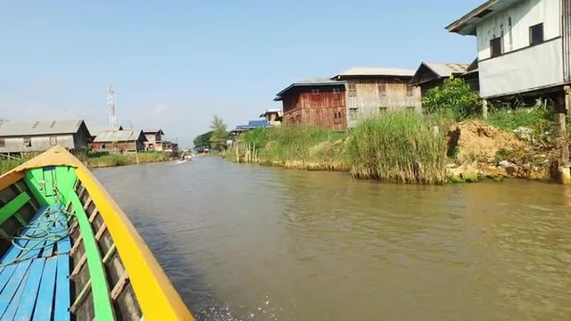 Boat rides thru village at the Inle lake in Myanmar.
