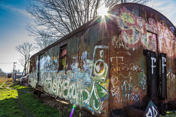 Old abandoned wagon spotted with graffiti.