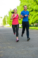 Fototapeta premium Runners training outdoors working out. City running couple jogging outside. 