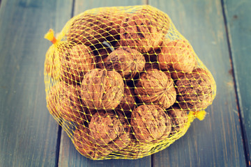 walnuts in plastic baf on blue wooden background