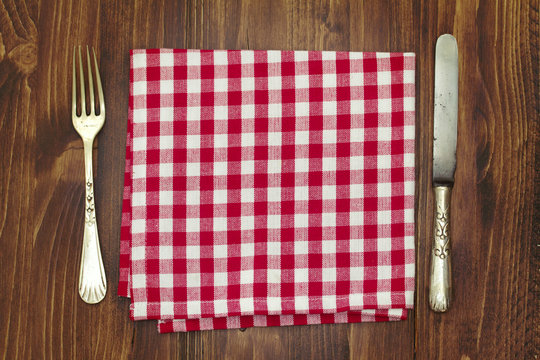 Fork With Knife And Napkin On Brown Wooden Background