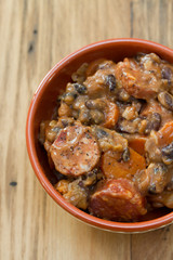typical portuguese dish feijoada in ceramic bowl on brown wooden background