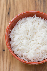 boiled rice on brown ceramic dish on brown wooden background