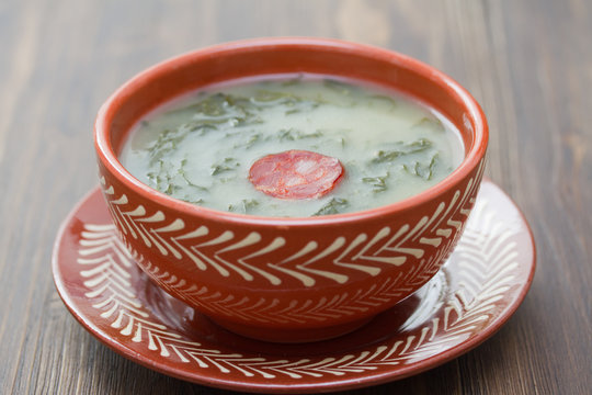 typical portuguese soup caldo verde in ceramic dish on wooden background