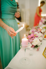 Lighting pink candle on wedding reception