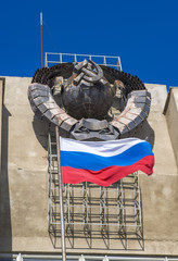 Российский флаг на фоне герба СССР, фокус на флаге