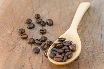 close up of Coffee beans with wooden spoon on grunge wooden background
