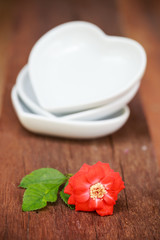 red rose and ceramic heart shape on old wooden