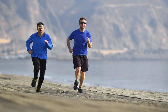 Two Men Friends Running Together On Beach Sand Coast Mountain Ba