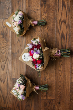 Fresh stylish roses wedding bouquets on wooden background closeu