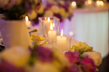 Romantic white candles at wedding reception table closeup
