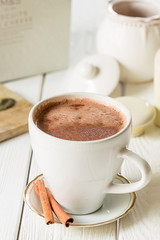 Hot Chocolate in White Beautiful Cup on Light White Wooden Background, Close-up