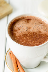 Hot Chocolate in White Beautiful Cup on Light White Wooden Background, Close-up