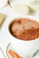 Hot Chocolate in White Beautiful Cup on Light White Wooden Background, Close-up, Vertical