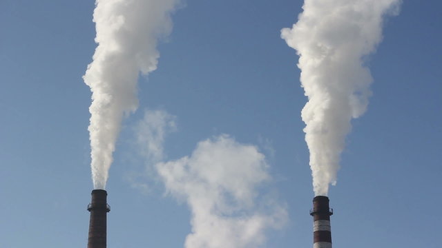 Cinemagraph - Factory chimney with smoke under blue sky - timelapse. Motion Photo.