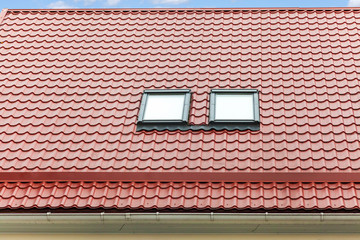 New red metal roof with skylights and rain gutter