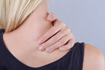 Woman with neck and back pain. Woman rubbing his painful back close up. Pain relief concept