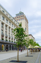Unrecognizable pedestrians walk along central Slovenska Street in front of Hotel Slon and Central Post. Ljubljana is the biggest city and capital of Slovenia.