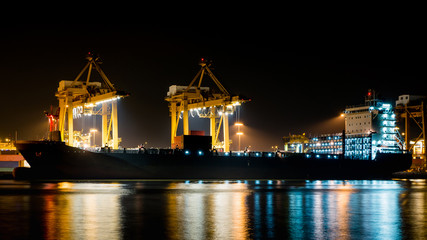 Fototapeta na wymiar Cargo ship unloading the container at Port during the night time