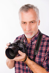 Portrait of aged photographer holding camera and going to make p