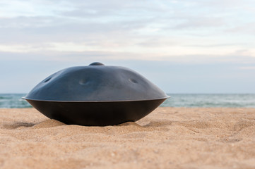 Close up of handpan or hang with sea and beach on Background. The Hang is traditional ethnic drum musical instrument