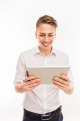 Pretty young businessman holding tablet and reading news