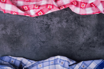 Top view of checkered kitchen tablecloth on granite -  concrete - stone background. Free space for your text or products.
