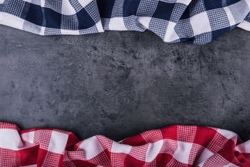 Top view of checkered kitchen tablecloth on granite -  concrete - stone background. Free space for your text or products.