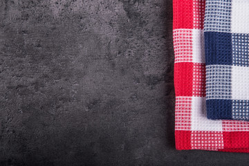 Top view of checkered kitchen tablecloth on granite -  concrete - stone background. Free space for your text or products.