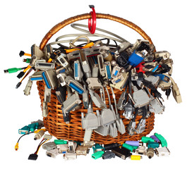 Basket with many different computer cables wires connectors sockets and plugs