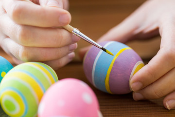 close up of woman hands coloring easter eggs