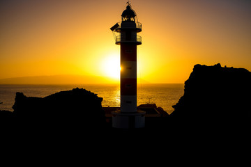 Coastline with lighthouse silhouette