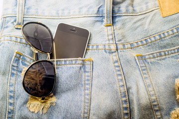 moblie phone and glasses in jeans pocket