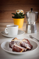 Slices of marble cake with a coffee on a white table